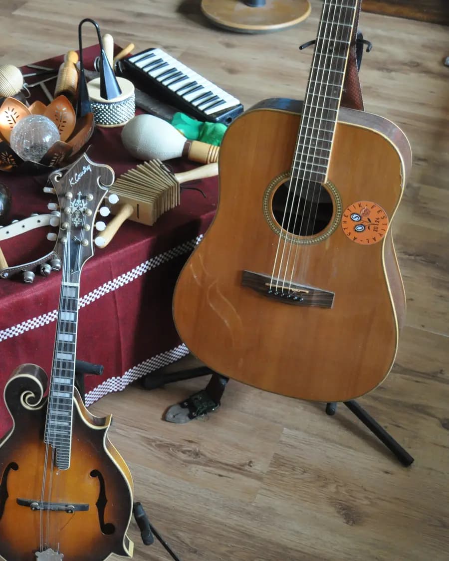Die Instrumente von Hans Hermsen: Westerngitarre auf dem Ständer, davor Mandoline und Ukulele