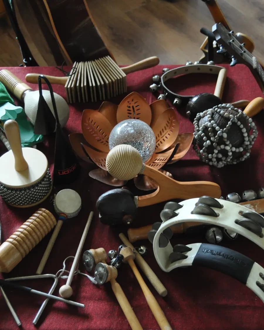 Ein Tisch voller Percussionsinstrumente: Melodica, Handtrommel, Klanghölzer, Rasseln, Schellenkranz und Tamburin